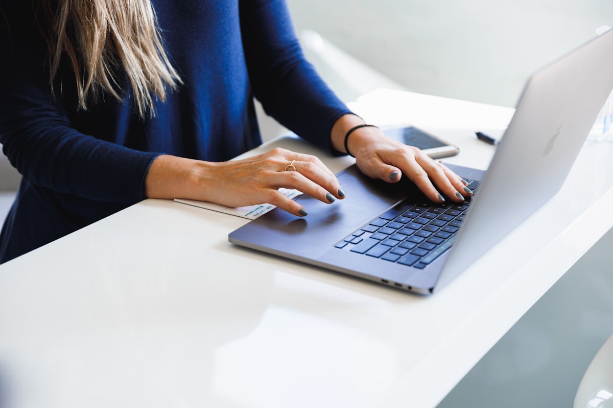 woman in blue long sleeve shirt using macbook