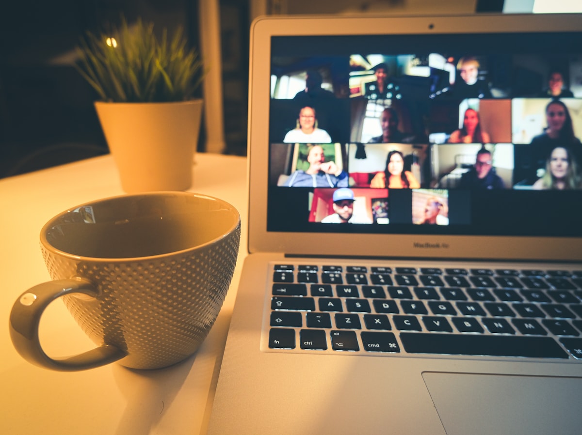 A laptop displaying a video conference with m